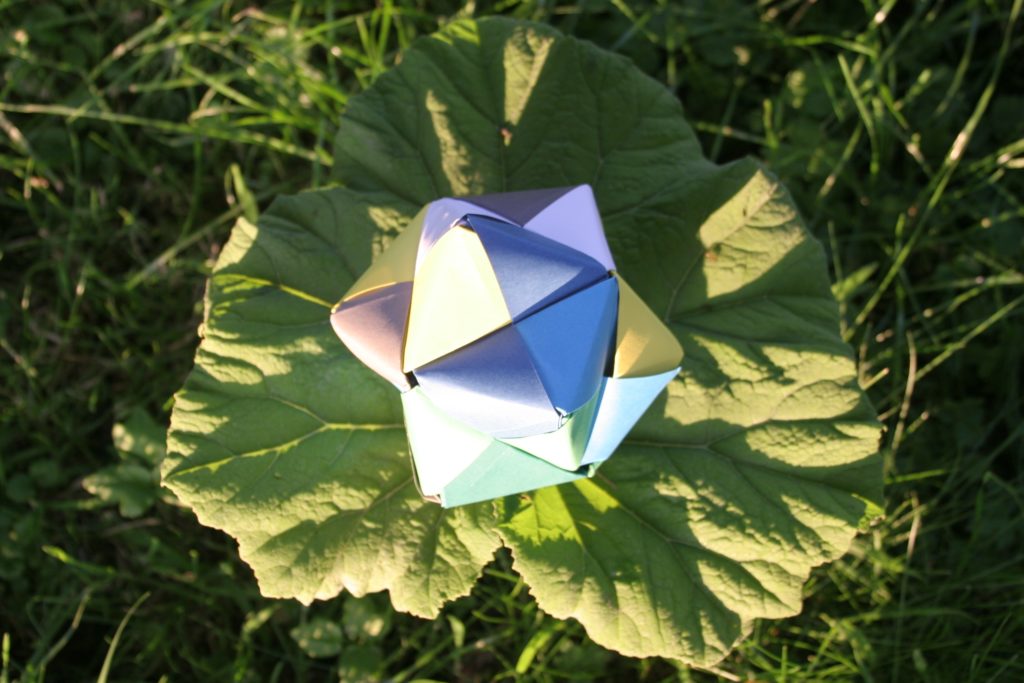 Een stervorm gevouwen van gekleurde stroken papier.